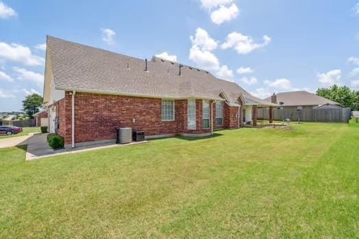 11416 Leslie Beachler Ln, Midwest City, OK 73130 - rear view of house featuring a lawn, brick siding, and a shingled roof