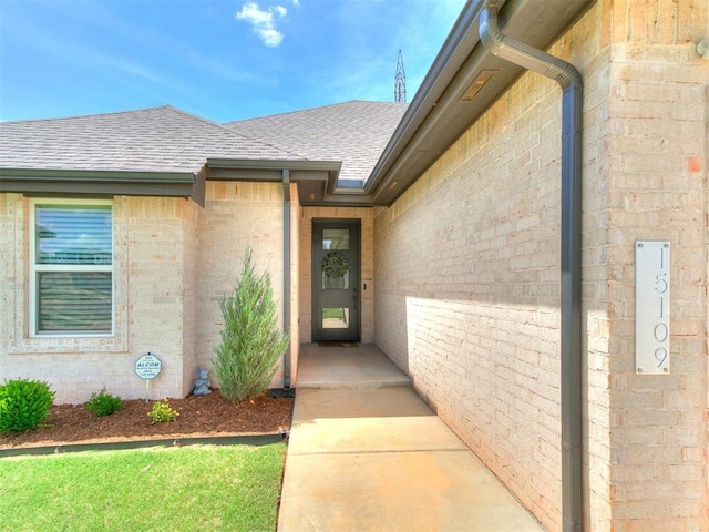 15109 Caspian Ln, Edmond, OK 73013 - property entrance with a shingled roof and brick siding