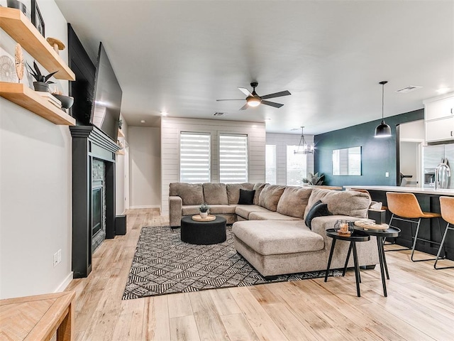 15109 Caspian Ln, Edmond, OK 73013 - living area featuring light wood-type flooring, a glass covered fireplace, and ceiling fan