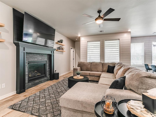 15109 Caspian Ln, Edmond, OK 73013 - living room with a ceiling fan, light wood finished floors, and a stone fireplace
