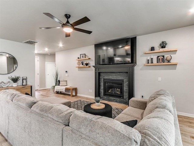 15109 Caspian Ln, Edmond, OK 73013 - living room with a ceiling fan, light wood finished floors, a glass covered fireplace, and recessed lighting