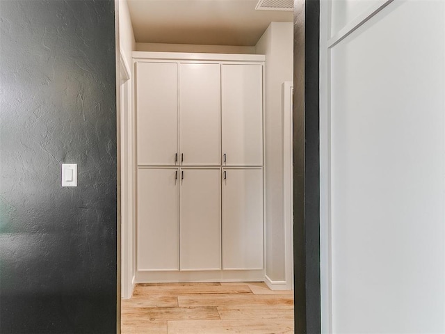 15109 Caspian Ln, Edmond, OK 73013 - hallway featuring light wood-type flooring and a textured wall