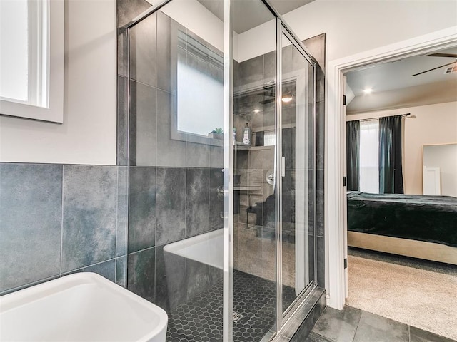 15109 Caspian Ln, Edmond, OK 73013 - ensuite bathroom with a bath, a stall shower, tile patterned flooring, and tile walls