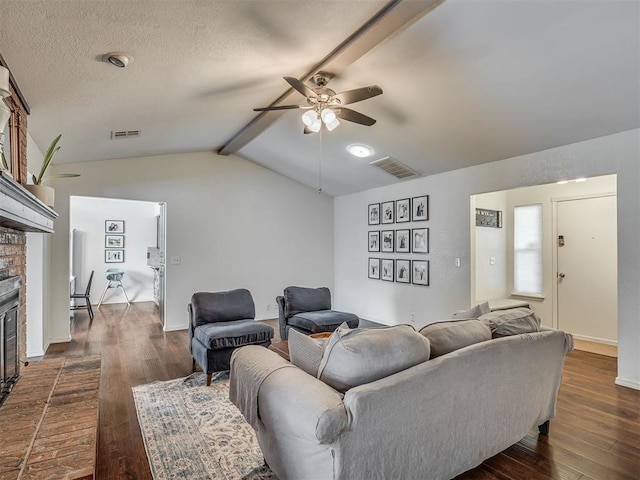 1008 S Neptune Rd, Edmond, OK 73003 - living room featuring a fireplace, ceiling fan, dark wood-style floors, and a textured ceiling