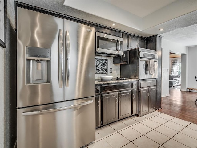 1008 S Neptune Rd, Edmond, OK 73003 - kitchen featuring stainless steel appliances, backsplash, light tile patterned floors, recessed lighting, and a textured ceiling