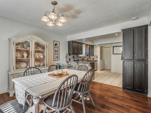 1008 S Neptune Rd, Edmond, OK 73003 - dining area with a chandelier, light wood finished floors, a textured ceiling, and washer / clothes dryer
