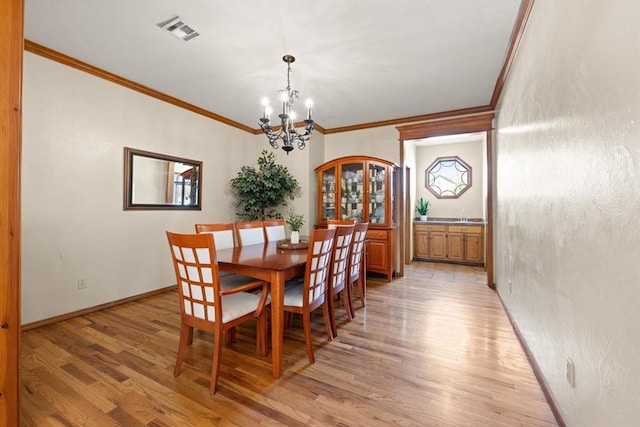 125 NW 147th St, Edmond, OK 73013 - dining space with a chandelier, ornamental molding, and light wood-type flooring