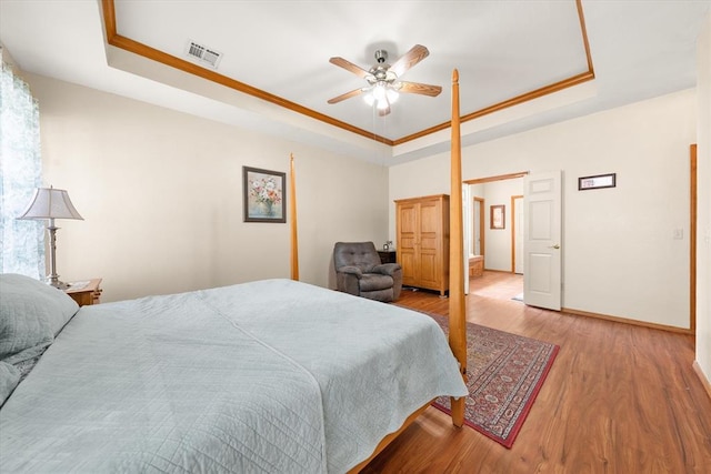 125 NW 147th St, Edmond, OK 73013 - bedroom featuring a raised ceiling, wood finished floors, ornamental molding, and ceiling fan