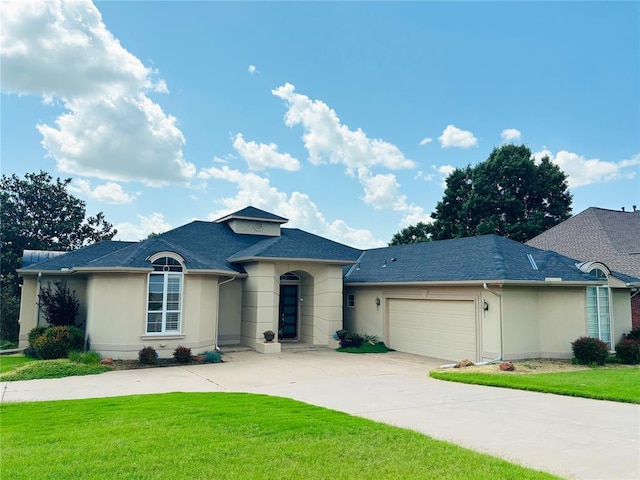 1004 Reginald Dr, Norman, OK 73072 - view of front of property with stucco siding, a front yard, a garage, and concrete driveway