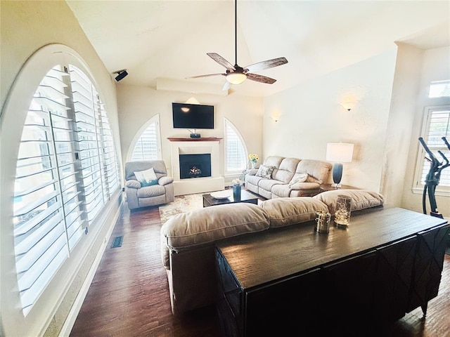 1004 Reginald Dr, Norman, OK 73072 - living room with wood finished floors, a ceiling fan, vaulted ceiling, and a warm lit fireplace