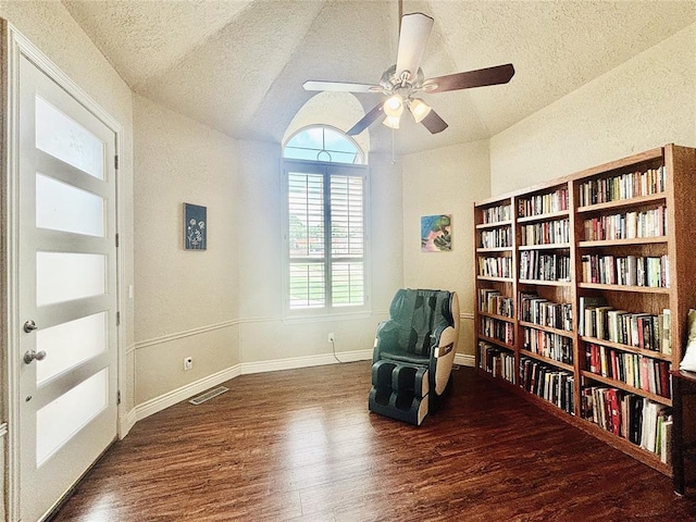 1004 Reginald Dr, Norman, OK 73072 - sitting room with a textured ceiling, wood finished floors, wall of books, a ceiling fan, and lofted ceiling