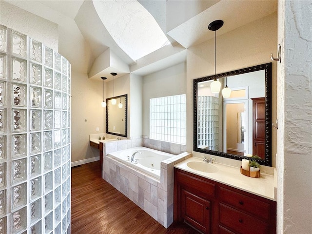 1004 Reginald Dr, Norman, OK 73072 - bathroom with a tub with jets, wood finished floors, and vanity