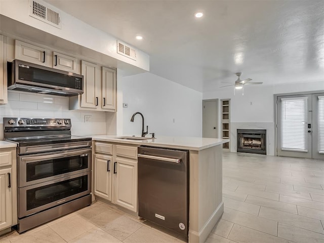 11550 N May Ave Unit 108, Oklahoma City, OK 73120 - kitchen with appliances with stainless steel finishes, a peninsula, a ceiling fan, light countertops, and tasteful backsplash