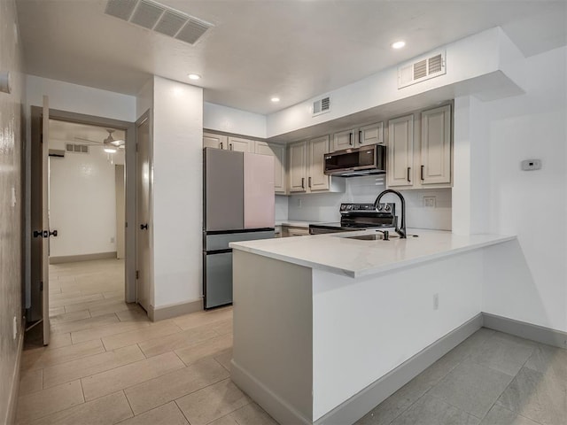 11550 N May Ave Unit 108, Oklahoma City, OK 73120 - kitchen with appliances with stainless steel finishes, a peninsula, light countertops, light tile patterned flooring, and recessed lighting