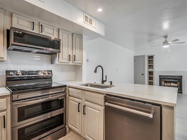 11550 N May Ave Unit 108, Oklahoma City, OK 73120 - kitchen featuring appliances with stainless steel finishes, a peninsula, a ceiling fan, light countertops, and tasteful backsplash