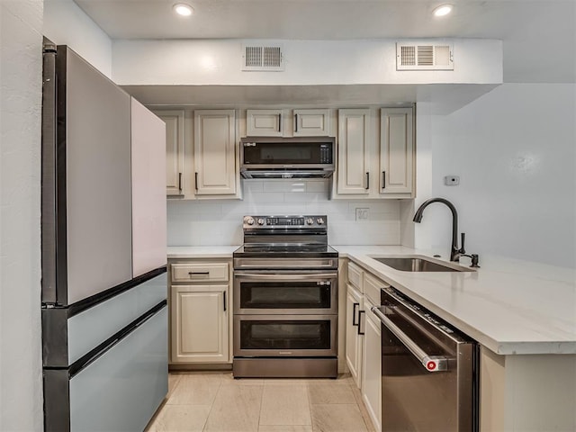 11550 N May Ave Unit 108, Oklahoma City, OK 73120 - kitchen featuring appliances with stainless steel finishes, a peninsula, backsplash, recessed lighting, and light tile patterned flooring