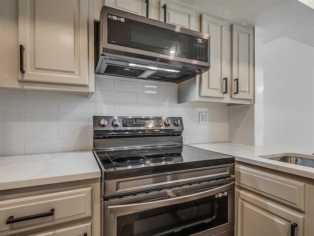 11550 N May Ave Unit 108, Oklahoma City, OK 73120 - kitchen with stainless steel appliances, backsplash, and light stone counters