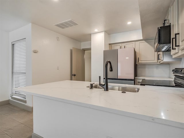 11550 N May Ave Unit 108, Oklahoma City, OK 73120 - kitchen with electric range oven, light stone countertops, freestanding refrigerator, recessed lighting, and light tile patterned floors