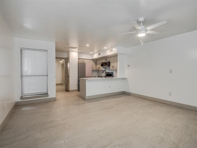 11550 N May Ave Unit 108, Oklahoma City, OK 73120 - kitchen with a peninsula, a ceiling fan, light countertops, freestanding refrigerator, and open floor plan
