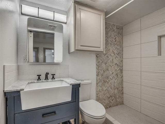 11550 N May Ave Unit 108, Oklahoma City, OK 73120 - bathroom featuring vanity, backsplash, and a tile shower