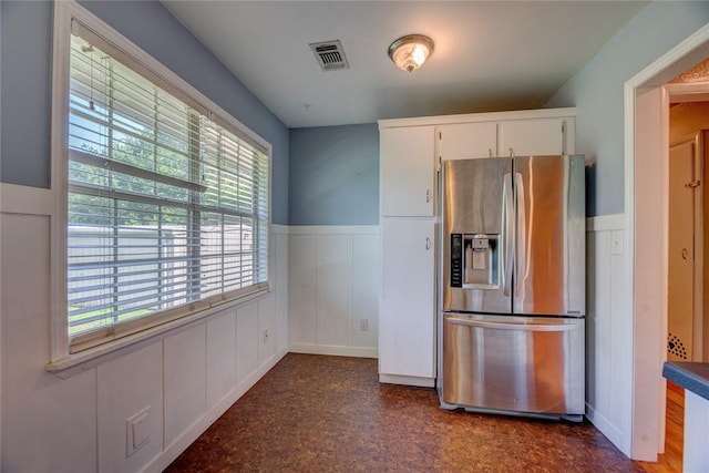 824 N Poplar Ln, Midwest City, OK 73130 - kitchen with stainless steel fridge with ice dispenser, wainscoting, white cabinets, dark floors, and a decorative wall