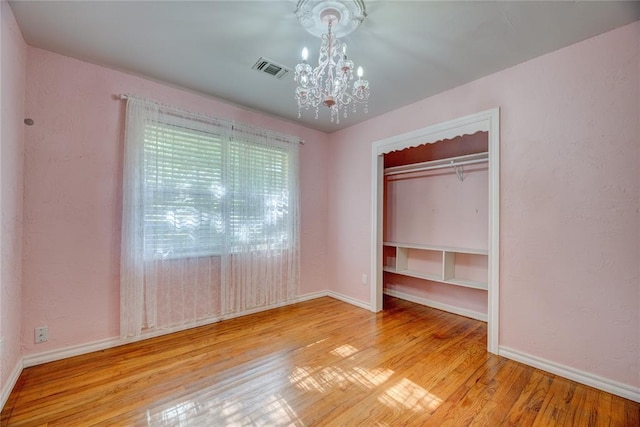 824 N Poplar Ln, Midwest City, OK 73130 - unfurnished bedroom with a chandelier, wood finished floors, and a closet