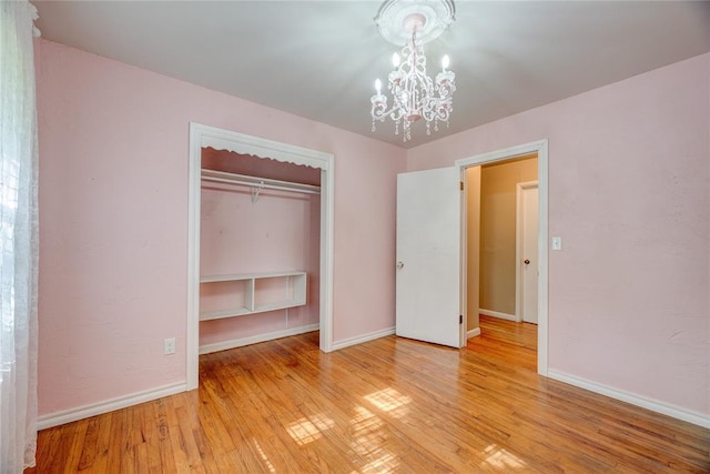 824 N Poplar Ln, Midwest City, OK 73130 - unfurnished bedroom featuring a closet, a chandelier, and light wood-style floors