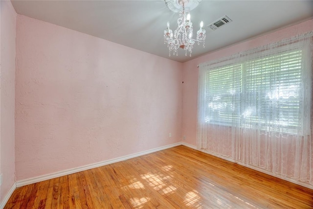 824 N Poplar Ln, Midwest City, OK 73130 - unfurnished room featuring a chandelier and light wood finished floors