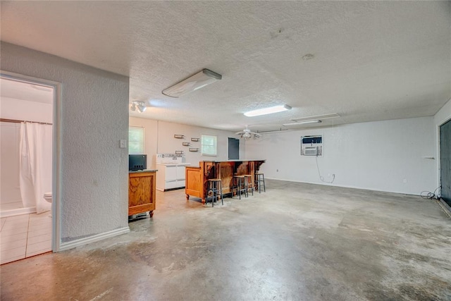 824 N Poplar Ln, Midwest City, OK 73130 - garage with washer / dryer, a wall unit AC, and a textured wall