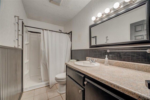 824 N Poplar Ln, Midwest City, OK 73130 - bathroom with a textured ceiling, a stall shower, vanity, tile patterned floors, and wainscoting