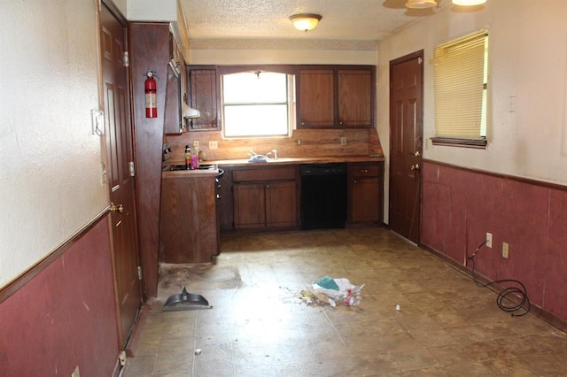 3916 SE 46th St, Oklahoma City, OK 73135 - kitchen with dishwasher, a wainscoted wall, brown cabinetry, and a textured ceiling