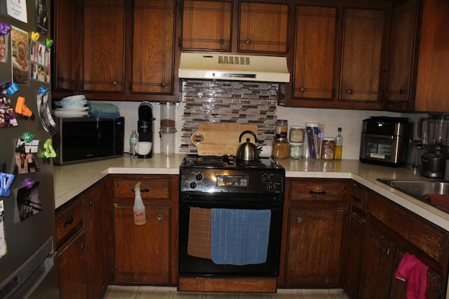 9607 NE 3rd Pl, Midwest City, OK 73130 - kitchen featuring black appliances, under cabinet range hood, light countertops, and decorative backsplash