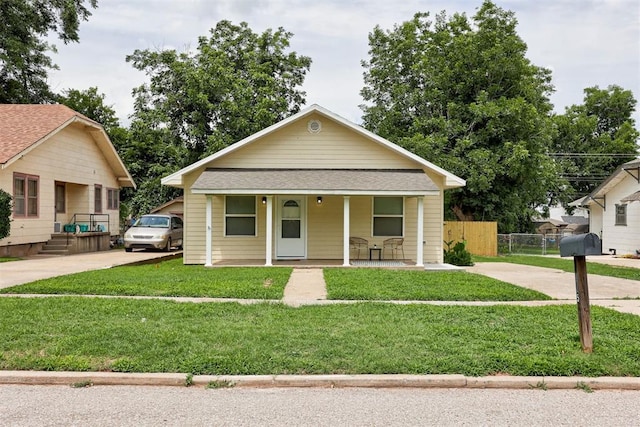825 Elm Ave, Yukon, OK 73099 - bungalow-style house with driveway, a porch, and roof with shingles