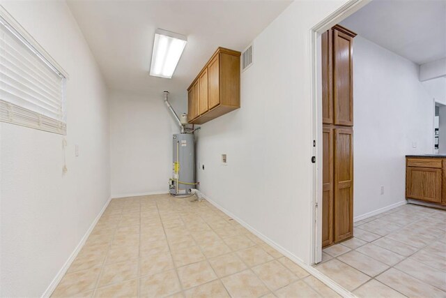825 Elm Ave, Yukon, OK 73099 - basement with gas water heater and light tile patterned flooring