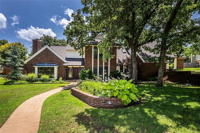 1504 Canary Pl, Edmond, OK 73034 - view of front of house with brick siding, a front yard, a chimney, and a shingled roof