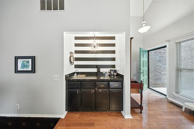 4713 N Cypress Ct, Oklahoma City, OK 73162 - bar area featuring light wood-style flooring, healthy amount of natural light, and pendant lighting