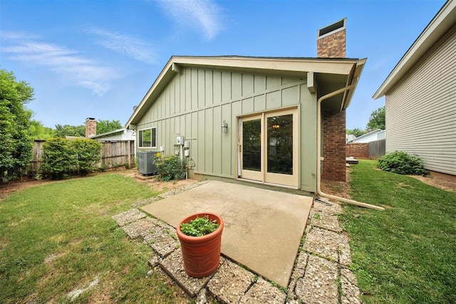 4713 N Cypress Ct, Oklahoma City, OK 73162 - back of property with board and batten siding, a chimney, and a patio area