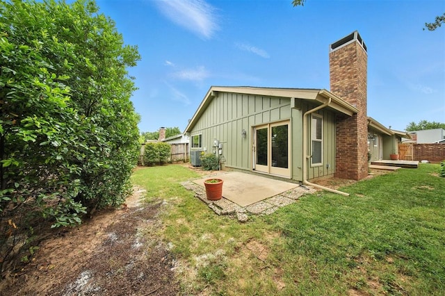 4713 N Cypress Ct, Oklahoma City, OK 73162 - rear view of property with board and batten siding, a chimney, and a patio area