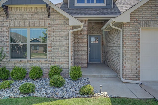 3800 Palmetto Trl, Oklahoma City, OK 73179 - view of exterior entry with a garage, a shingled roof, and brick siding