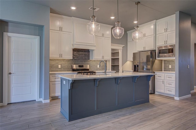 3800 Palmetto Trl, Oklahoma City, OK 73179 - kitchen featuring appliances with stainless steel finishes, a breakfast bar area, light countertops, white cabinets, and recessed lighting