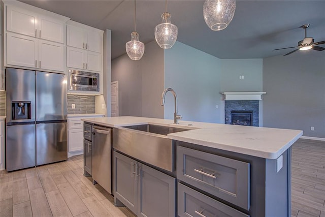 3800 Palmetto Trl, Oklahoma City, OK 73179 - kitchen with stainless steel appliances, light wood finished floors, open floor plan, decorative backsplash, and ceiling fan