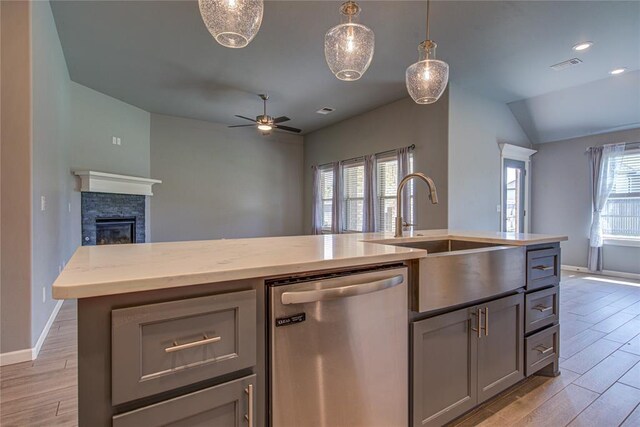 3800 Palmetto Trl, Oklahoma City, OK 73179 - kitchen featuring stainless steel dishwasher, open floor plan, light wood-style floors, a fireplace, and lofted ceiling