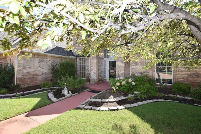 12608 Redstone Ct, Oklahoma City, OK 73142 - view of exterior entry with brick siding and a yard