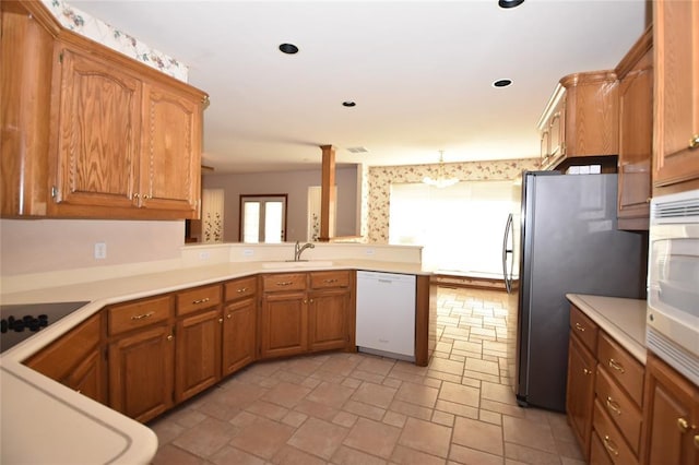 12608 Redstone Ct, Oklahoma City, OK 73142 - kitchen with white dishwasher, black electric cooktop, a peninsula, light countertops, and freestanding refrigerator