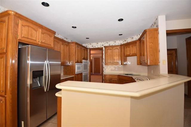 12608 Redstone Ct, Oklahoma City, OK 73142 - kitchen featuring white appliances, a peninsula, light countertops, and brown cabinetry