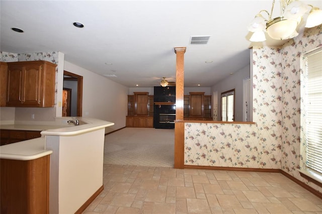 12608 Redstone Ct, Oklahoma City, OK 73142 - kitchen with a ceiling fan, a peninsula, light stone finish flooring, brown cabinetry, and open floor plan