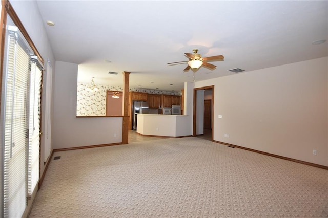 12608 Redstone Ct, Oklahoma City, OK 73142 - unfurnished living room with light colored carpet, ceiling fan, and ornate columns