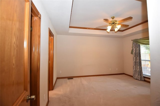 12608 Redstone Ct, Oklahoma City, OK 73142 - empty room with light colored carpet, a ceiling fan, a raised ceiling, and crown molding