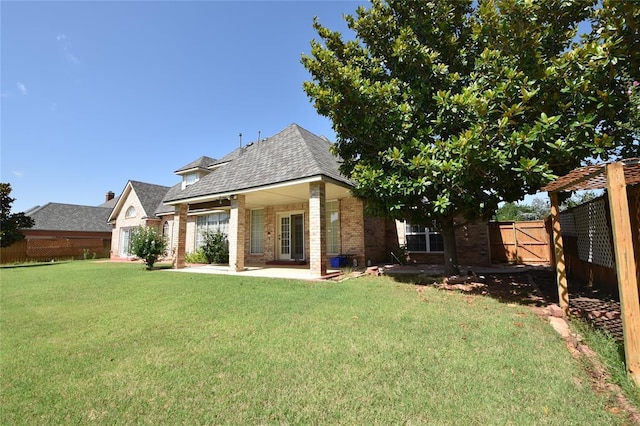 12608 Redstone Ct, Oklahoma City, OK 73142 - back of house featuring brick siding, a fenced backyard, a patio area, and a shingled roof