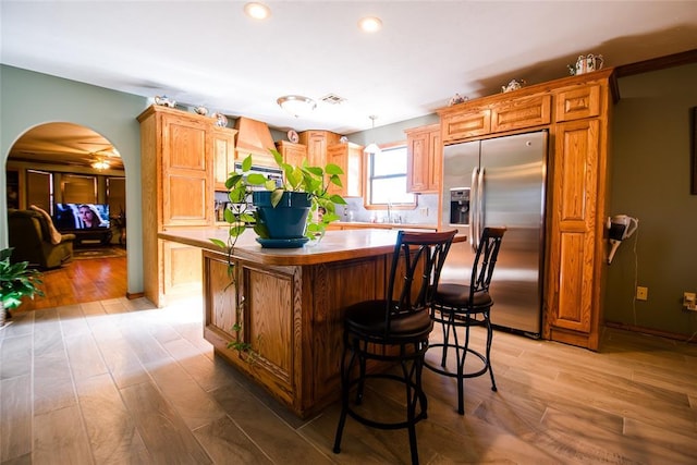23281 N Pvt 3227 Dr, Pauls Valley, OK 73075 - kitchen with stainless steel refrigerator with ice dispenser, a kitchen island, arched walkways, light wood finished floors, and recessed lighting